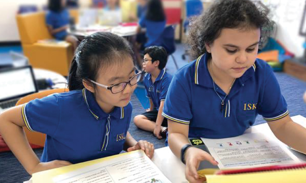 Elementary school students reading a social studies worksheet
